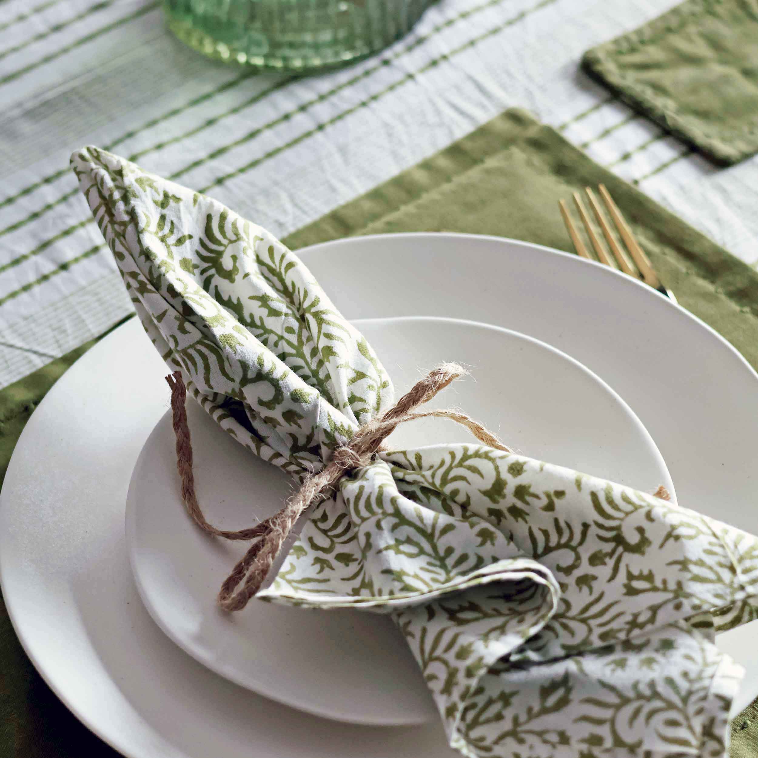 A close up picture of a green block printed napkin