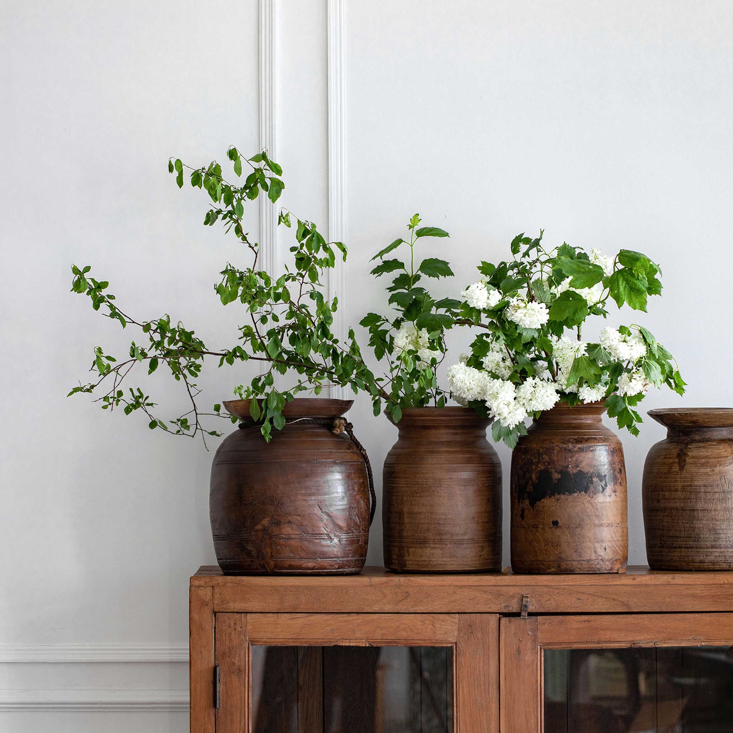 A row of solid teak antique urns